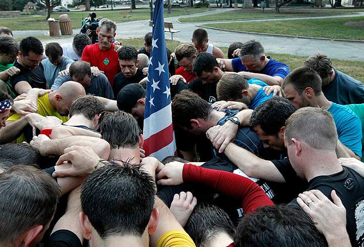A group of about 60 men organized by the F3 fitness fellowship gather to say a prayer for the victims of the 9/11 attacks after their run in downtown Raleigh, North Carolina, Wednesday, September 11, 2013 to commemorate the 12th anniversary of the runs rescue workers made at the World Trade Centers in New York City following the terrorist attacks on Sept. 11, 2001. (Photo credit: Getty Images)