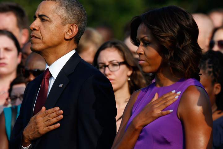 President Barack Obama and first lady Michelle Obama put their hands on their hearts during the playing of “Taps” as they stand on the South Lawn of the White House in Washington, Wednesday, September 11, 2013, to mark the 12th anniversary of the September 11 terror attacks.  (Photo credit: AP Photo)