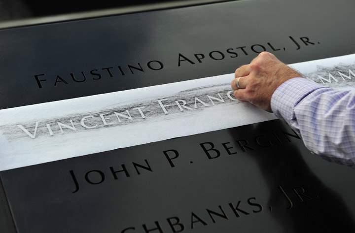 Ron Joy makes a rubbing of his friend’s name, New York Fire Department firefighter Capt. Vincent Giammona, at the South reflecting pool at the 9/11 Memorial on Wednesday, Sept. 11, 2013, during ceremonies marking the 12th anniversary of the Sept. 11 terrorist attacks in New York.  (Photo credit: AP Photo)