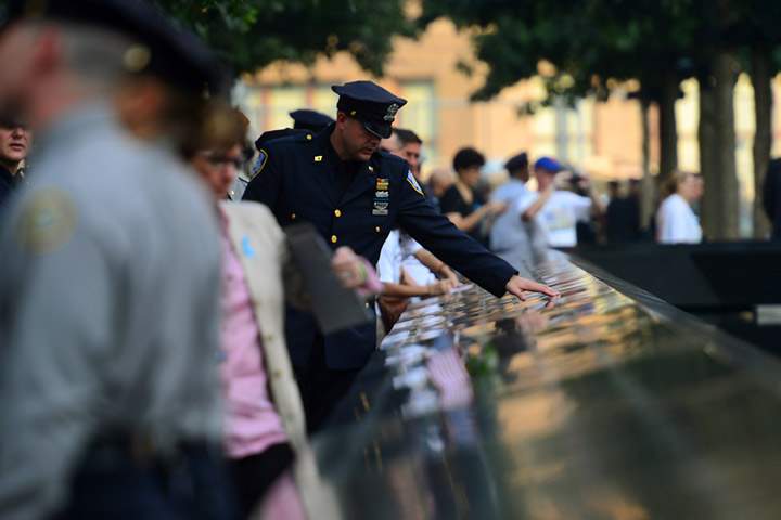 A Port Authority Police Officer touches the 9/11 Memorial during ceremonies for the twelfth anniversary of the terrorist attacks on lower Manhattan at the World Trade Center site on September 11, 2013 in New York City.  (Photo credit: Getty Images)