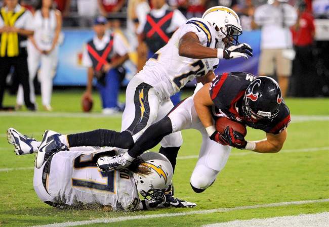 Houston Texans tight end Garrett Graham, right, scores between San Diego Chargers linebacker Bront Bird, left, and running back Ronnie Brown during the second half of an NFL football game.