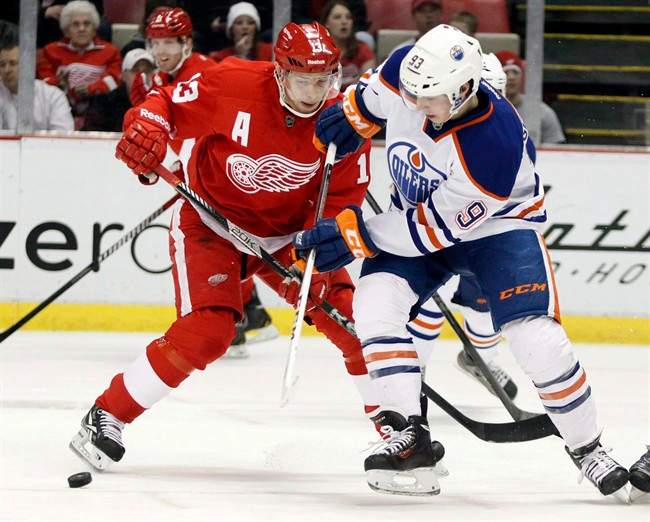 Detroit Red Wings Pavel Datsyuk (13) and Edmonton Oilers center Ryan Nugent-Hopkins (93) chase a loose puck during the first period of an NHL hockey game on Thursday, March 7, 2013, in Detroit.