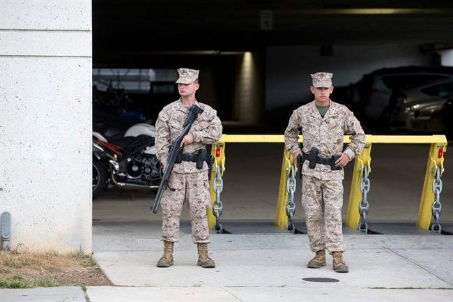 Members of the military guard a military garage near the Washington Navy Yard where a gunman was reported in Washington, on Monday, Sept. 16, 2013. (AP Photo/Jacquelyn Martin)