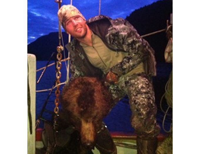 Clayton Stoner, a NHL player, has confirmed he is the person holding up a grizzly bear head in this photo taken in May and released to media on September 3, 2013.