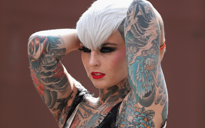 A tattooed model poses for photographers at the London Tattoo Convention in Tobacco Dock on September 27, 2013 in London, England. Photo by Oli Scarff/Getty Images
