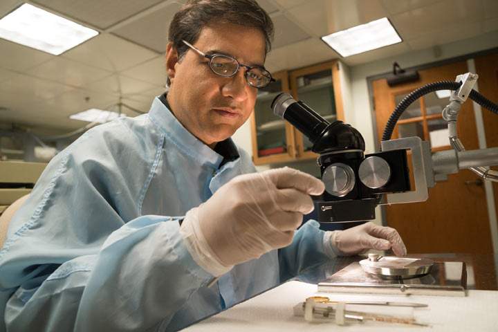 Using a binocular microscope, Dartmouth geochemist Mukul Sharma examines impact-derived spherules that he and his colleagues regard as evidence of a climate-altering meteor or comet impact 12,900 years ago.  