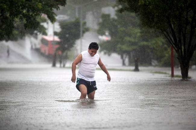A man walks through a flooded street during heavy rains caused by Tropical Storm Ingrid in the Gulf port city of Veracruz, Mexico, Friday Sept. 13., 2013. Mexican authorities rushed to evacuate neighborhoods located near riverbanks in eight Veracruz townships as Ingrid lashed the coast with heavy rains, threatening more damage in a state where landslides and flooding have killed dozens of people in recent weeks.
