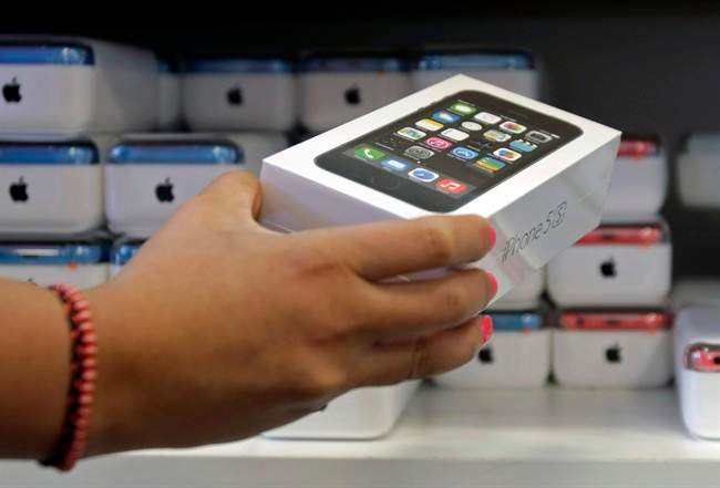 A sales person pulls out an iPhone 5s for a customer during the opening day of sales of the iPhone 5s and iPhone 5C.