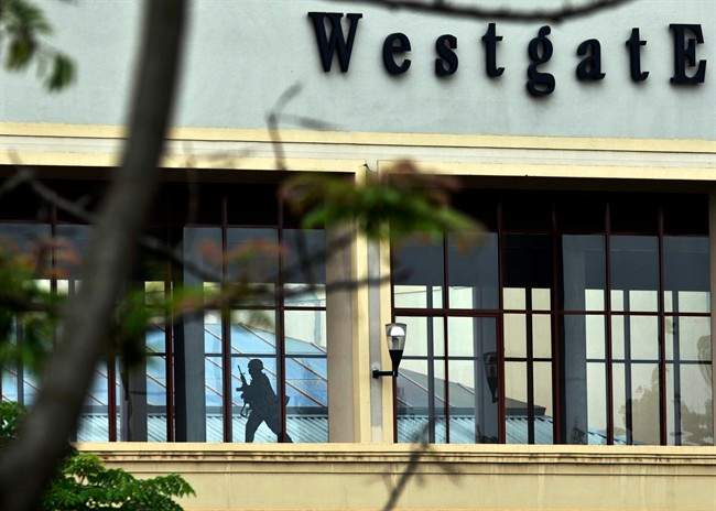 In this Tuesday, Sept. 24, 2013, file photo, a Kenyan soldier runs through a corridor on an upper floor, shortly before an explosion was heard, at the Westgate Mall in Nairobi, Kenya. 