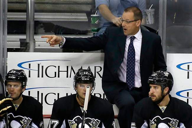In this photo taken on Sept. 23, 2013, Pittsburgh Penguins head coach Dan Bylsma works from the bench during an NHL preseason hockey game against the Chicago Blackhawks in Pittsburgh.
