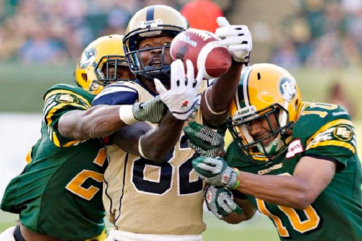 Winnipeg Blue Bombers' Terrence Edwards (centre) misses the catch as the Edmonton Eskimos' Marcell Young (left) and Donovan Alexander (right) defend in Edmonton last season. The worst teams in the CFL last season, they both bring 3-0 records to their first meeting this year.