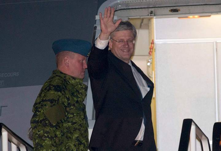 Prime Minister Stephen Harper waves as he arrives in Brussels, Belgium Friday October 18, 2013.