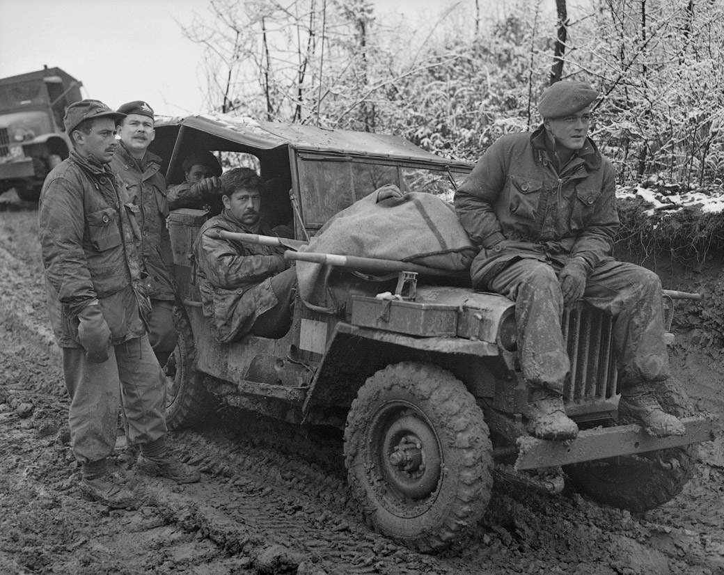 The morning after an artillery attack in Korea in November of 1951. Canadian troops wait to take a soldier's body away for burial. 