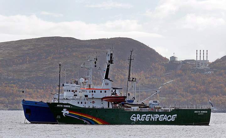 Greenpeace ship 'Arctic Sunrise' is escorted by a Russian coast guard boat, in Kola Bay at the military base Severomorsk on the Kola peninsula in Russia, at dawn Tuesday, Sept. 24, 2013.