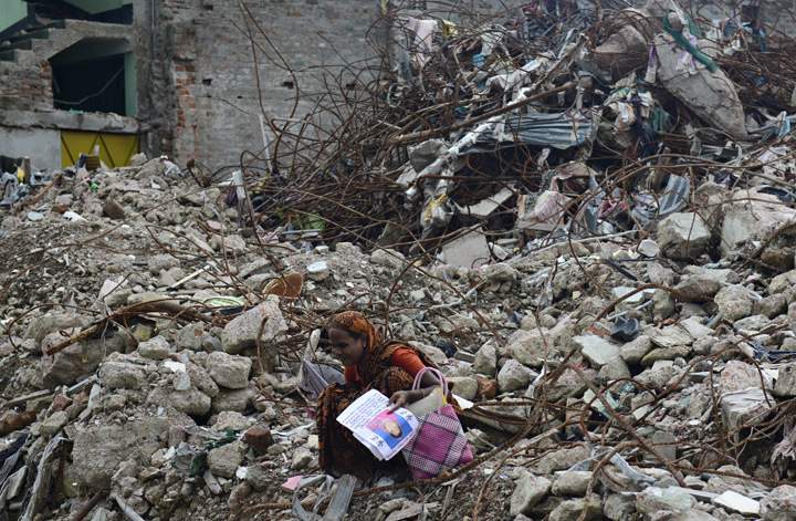 A mourner grieves for her relative, missing and presumed dead, at the scene of the April 24 Rana Plaza garment building collapse during the one hundredth-day anniversary of the disaster in Savar, on the outskirts of Dhaka, on August 2, 2013. (Photo credit: Getty Images)
