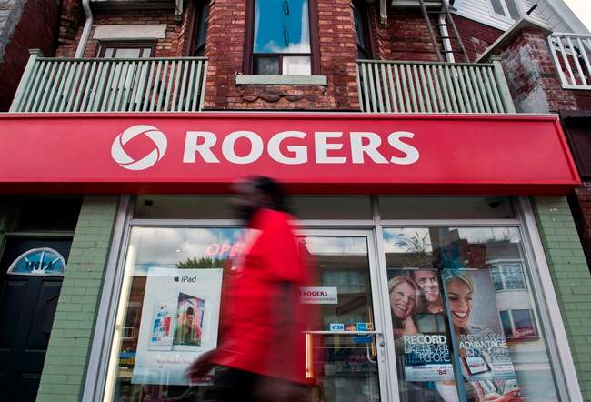 A man walks by a Rogers store in Toronto, Wednesday, August 15, 2013.