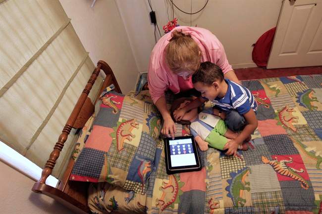 Denise Thevenot and her son Frankie Thevenot, 3, play with an iPad in his bedroom at their home in Metairie, La., on Oct. 21, 2011.