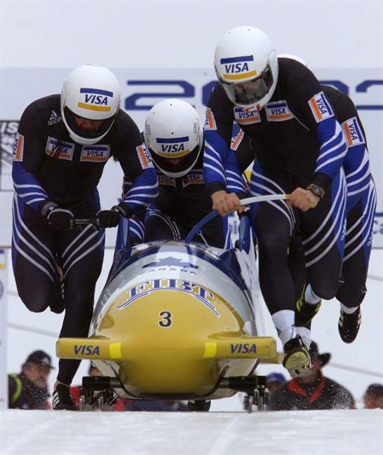 FILE: Canadians Pierre Lueders (right), Ben Hindle (left), Ken LeBlanc (centre) and Mark LeBlanc (back right) push their sleigh at the start of the 4-Man World Cup Bobsled heats in Calgary, Sunday February 18, 2001. 