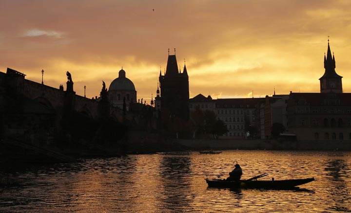 A fisherman waits for a catch underneath the medieval Charles Bridge as the sun rises in Prague, Czech Republic, Thursday, Oct. 17, 2013.  AP Photo/Petr David Josek.
