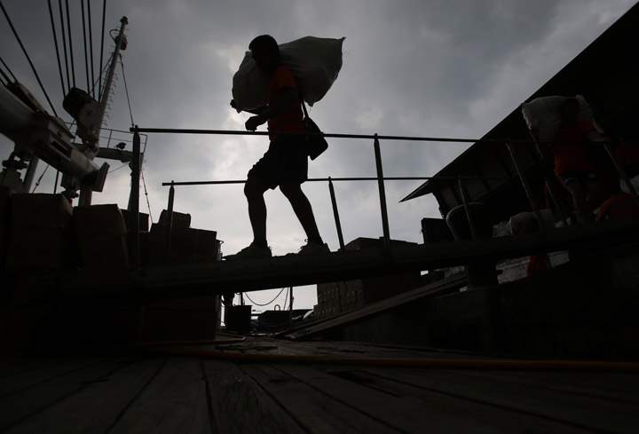 A Philippine Coast Guard crew carries relief goods on a Coast Guard ship docked at Manila’s pier, Philippines, before heading to earthquake-struck Cebu and Bohol provinces on Wednesday, Oct. 16, 2013. (Photo credit: AP Photo)