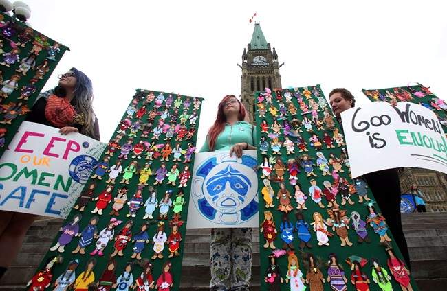 Women take part in a rally on Parliament Hill in Ottawa on Friday, October 4, 2013 by the Native Women's Assoiciation of Canada honouring the lives of missing and murdered Aboriginal women and girls. THE CANADIAN PRESS/Fred Chartrand.