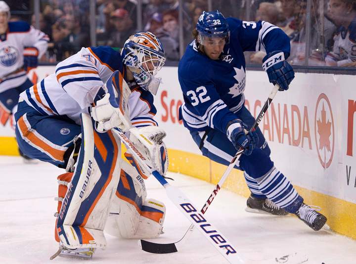 Toronto Maple Leafs Josh Leivo (32) and Edmonton Oilers goaltender Devan Dubnyk battle for the puck during second period NHL action in Toronto on Saturday October 12, 2013.