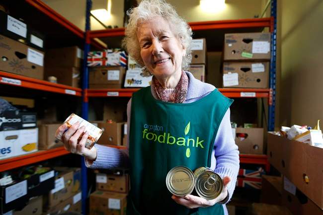 Food bank volunteer Diana Grant sorts cans in this file photo.