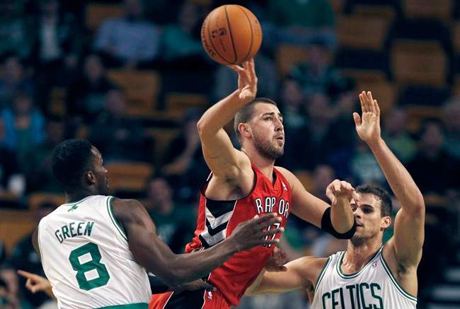 Toronto Raptors center Jonas Valanciunas (17), of Lithuania, passes as he is pressured by Boston Celtics forwards Jeff Green (8) and Kris Humphries during the first quarter of a preseason NBA basketball game, Monday, Oct. 7, 2013, in Boston.