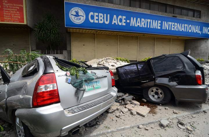 Cars damaged by falling debris in downtown Cebu City, Philippines after a major 7.2 magnitude earthquake struck the region on October 15, 2013. (Photo credit: Getty Images)