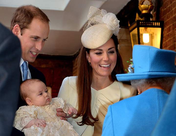 Britain’s Prince William, Duke of Cambridge and his wife Catherine, Duchess of Cambridge, speak with Queen Elizabeth II as they hold their son Prince George of Cambridge at Chapel Royal in St James’s Palace in central London on October 23, 2013. (Photo credit: Getty Images)