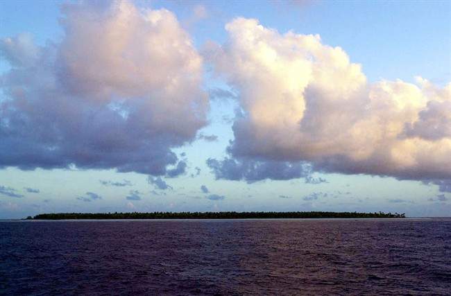  In this Dec. 30, 1999 file photo, clouds float over the Millennium Island, Kiribati, in the South Pacific. 