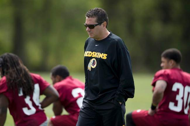 In this photo taken May 5, 2013, Washington Redskins owner Dan Snyder walks by players during a rookie minicamp practice session at Redskins Park in Ashburn, Va.