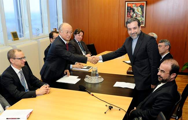 Iran's deputy Foreign Minister Abbas Araghchi, right, and Director General of the International Atomic Energy Agency, IAEA, Yukiya Amano shake hands next to IAEA deputy director general Tero Tapio Varjoranta, left, and Iran's Ambassador to the International Atomic Energy Agency, IAEA, Reza Najafi, right, prior a meeting at the International Center in Vienna, Austria on Monday, Oct. 28, 2013. 