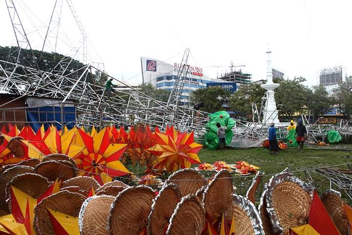 Workers examine the damage after a giant Christmas tree was toppled by strong winds at the onslaught of the powerful typhoon Haiyan. (AP Photo Chester Baldicantos)