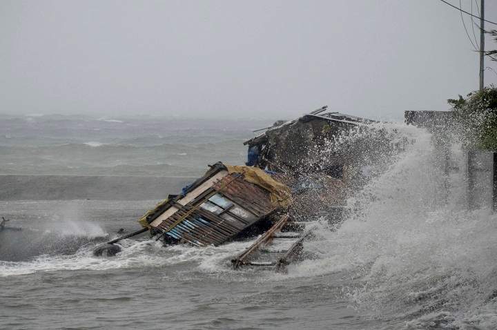 A house is engulfed by the storm surge brought about by powerful typhoon Haiyan that hit Legazpi city, Albay province. (AP Photo/Nelson Salting)