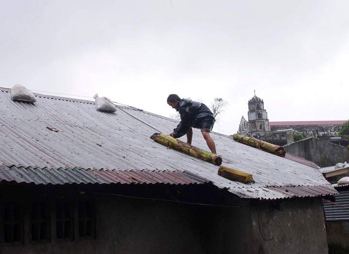 A man reinforces his house with banana stalks as powerful typhoon Haiyan hits Legazpi city, Albay province. (AP Photo/Nelson Salting)