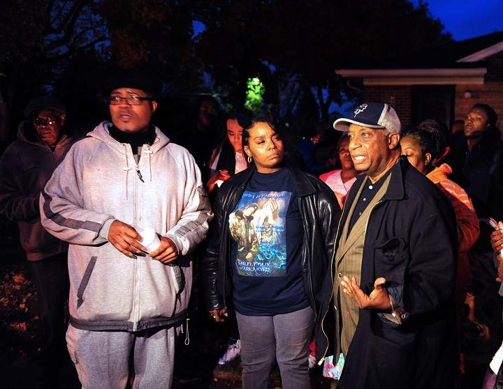 In this Wednesday, Nov. 6, 2013 photo, from left, Pastor W. J. Rideout, Renisha McBride’s aunt Bernita Spinks and Ron Scott speak to the media during a vigil in Dearborn Heights, Mich., for Renisha McBride in the front of the home where she shot early Saturday. No charges have been filed after authorities said McBride, of Detroit, was killed by a shotgun blast to the face early Saturday in Dearborn Heights. According to police, the homeowner told investigators that he thought someone was trying to break into his home and accidentally discharged the gun.
