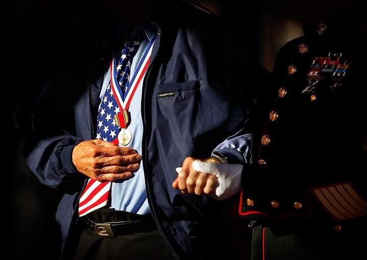 Marine Corps veteran Jim Brown, 83, (right) who served in Vietnam and Korea helps D-Day Veteran Howard Mills, 91, to the stage for special recognition during a Veteran’s Day ceremony organized by Forever Young Senior Veteran Wish at Collierville Town Square in Collierville, Tenn. Sunday, Nov. 10, 2013. (AP Photo/The Commercial Appeal, Jim Weber)