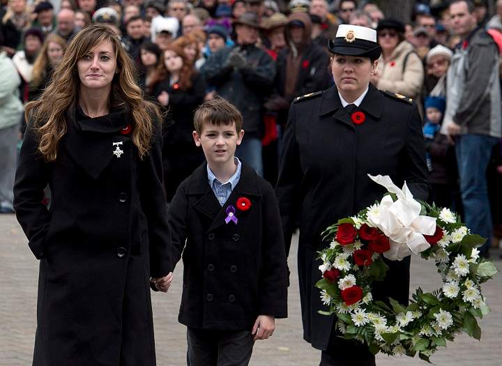 Memorial Cross recipient Priscilla Blake, and her son Tie head to lay a wreath at Remembrance Day cermonies at the Grand Parade in Halifax on Monday, Nov. 11, 2013. Her husband, Petty Officer (second class) Craig Blake, a navy clearance diver was killed by by an explosive device in Afghanistan in 2010. (The Canadian Press/Andrew Vaughan)