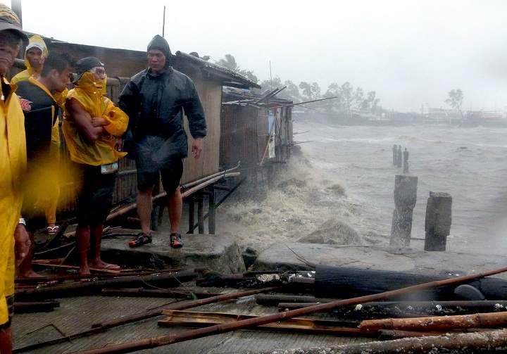 People stand at the pier as Super Typhoon Haiyan smashes into coastal communities on the central island of Bacalod. (JULIUS MARIVELES/AFP/Getty Images)