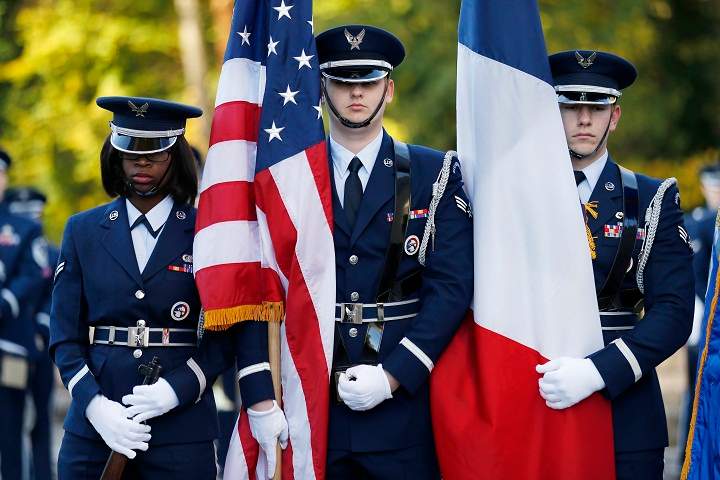 US Air Force soldiers hold French and US flags as they attend the Remembrance Day ceremony at The Lafayette Escadrille Memorial of Marnes-la-Coquette, east of Paris, on November 11, 2013. (Thomas Samson/Getty Images)