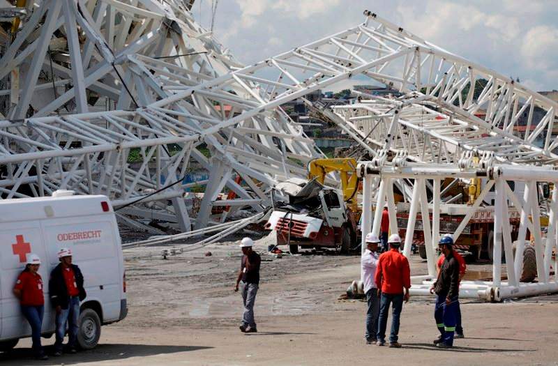 People stand near a metal structure that buckled on part of the Itaquerao Stadium in Sao Paulo, Brazil, Wednesday, Nov. 27, 2013. Part of the stadium that will host the 2014 World Cup opener in Brazil collapsed on Wednesday, causing significant damage and killing at least two people, authorities said. (AP Photo/Nelson Antoine).