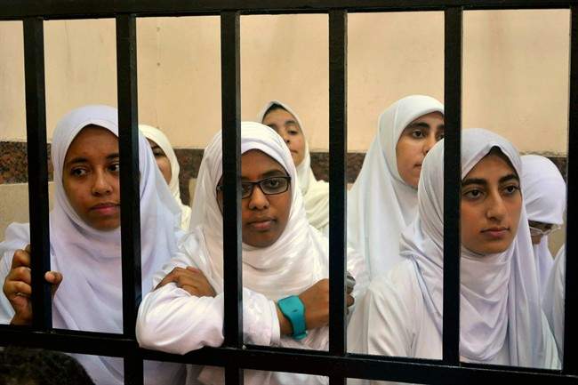 Egyptian women supporters of ousted President Mohammed Morsi stand inside the defendants' cage in a courtroom in Alexandria, Egypt, Wednesday, Nov. 27, 2013.