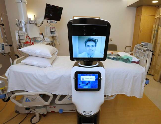 In this photo taken Wednesday, Nov. 6, 2013, Dr. Alan Shatzel, medical director of the Mercy Telehealth Network, is displayed on the monitor RP-VITA robot at Mercy San Juan Hospital in Carmichael, Calif. The robots enable physicians to have a different bedside presence as they "beam" themselves into hospitals to diagnose patients and offer medical advice during emergencies. (AP Photo/Rich Pedroncelli).