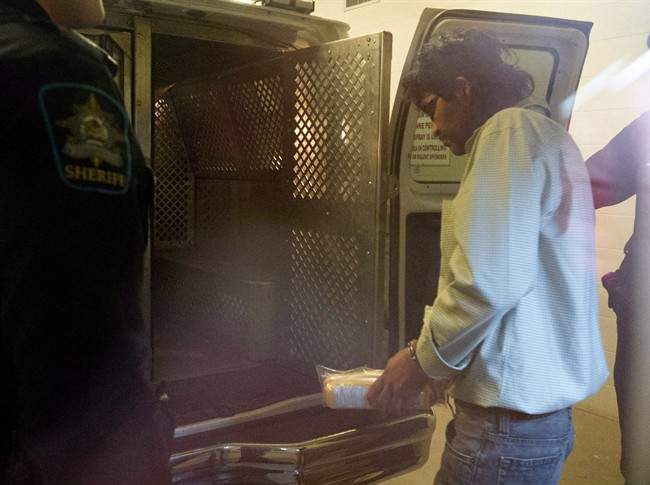 Richard Benson is taken back into custody from the courthouse in St. Paul, Alta., Monday, Oct. 29, 2012.