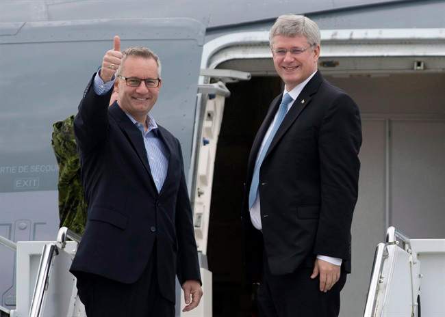 Canadian Prime Minister Stephen Harper, right, and International Trade Minister Ed Fast, leave Ottawa for Europe on October 17, 2013. THE CANADIAN PRESS/Adrian Wyld.