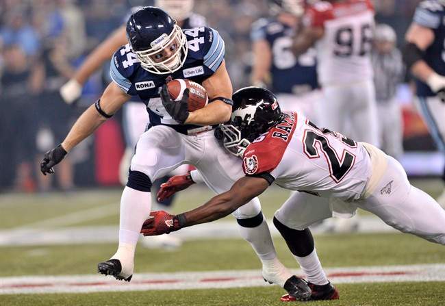 Toronto Argonauts running back Chad Kackert runs the ball against Calgary Stampeders defensive back Keon Raymond during the first quarter of the CFL Grey Cup Sunday November 25, 2012 in Toronto.