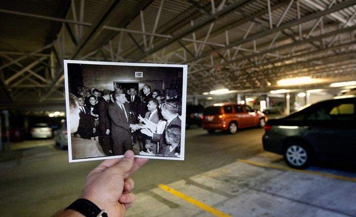 This Oct. 22, 2013 photo shows an image taken by Alexander Arroyos on Nov. 21, 1963, of U.S. President John F. Kennedy and first lady Jacqueline Kennedy in the Grand Ballroom at the Rice Hotel, juxtaposed against the current parking garage at the Rice Hotel, in Houston. Kennedy was assassinated the following day. The Grand Ballroom no longer exists after the hotel was remodelled making it into a parking garage. (AP Photo/Houston Chronicle, Cody Duty)