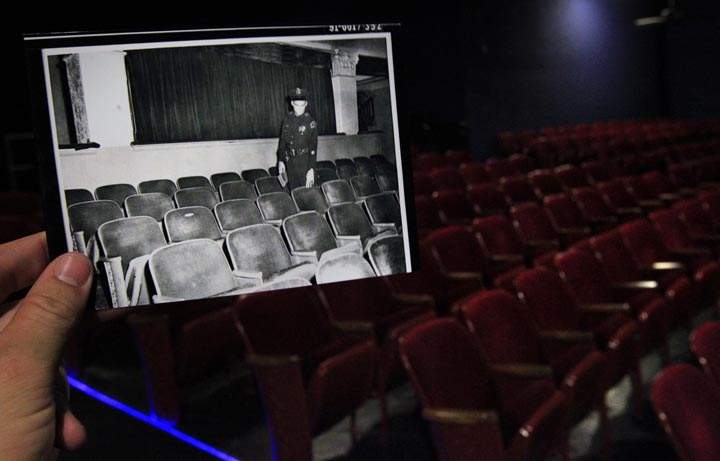 This Sept. 9, 2013 photo shows an image provided by the City of Dallas Archive taken Nov. 22, 1963, of a Dallas police officer pointing to the seat at the Texas Theatre where Lee Harvey Oswald was sitting when police entered to arrest him, juxtaposed against the current scene in Dallas. (AP Photo/Houston Chronicle, Cody Duty)