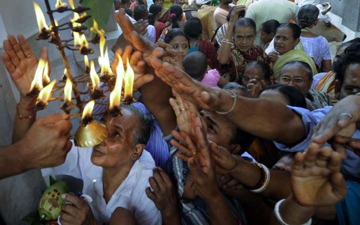 Indian Hindu devotees gather as they attempt to collect blessings during Annakut celebrations at a temple at Agartala on November 4, 2013. (Photo credit: Getty Images)